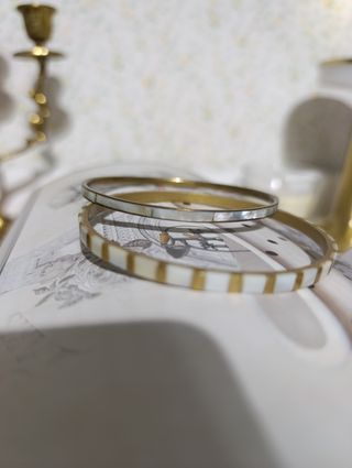 Dos pulseras rígidas doradas con nácar