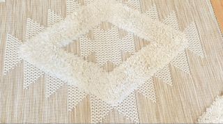 Alfombra beige y blanca con diseño geométrico