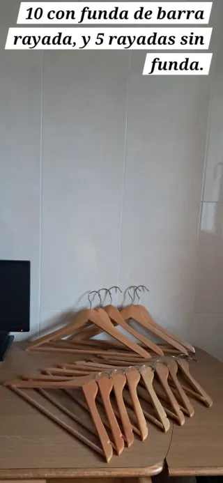 15 perchas de madera con barra rayada.