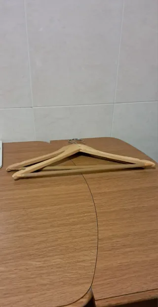 15 perchas de madera con barra rayada.