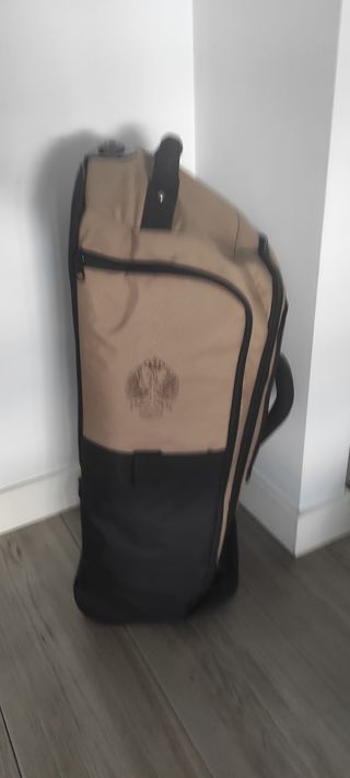 Maleta de viaje beige y negra con ruedas