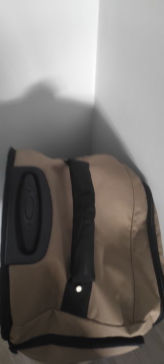 Maleta de viaje beige y negra con ruedas