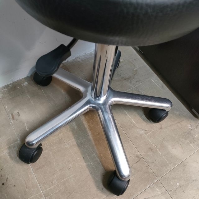 Taburete médico con ruedas y altura regulable.