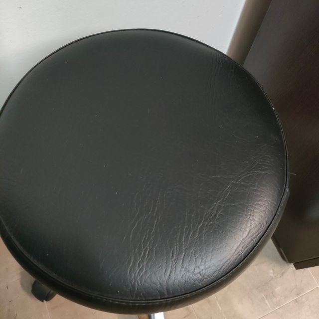 Taburete médico con ruedas y altura regulable.