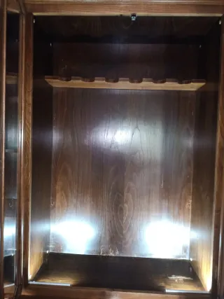 Armario armero de madera con puertas de cristal.