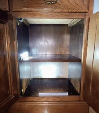 Armario armero de madera con puertas de cristal.