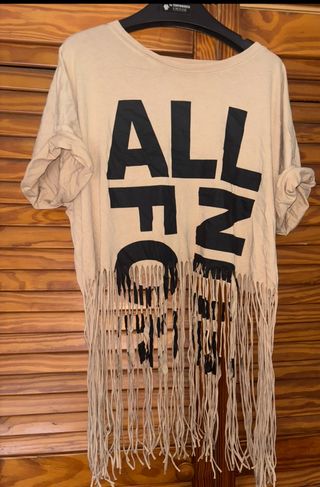 Camiseta beige con flecos y estampado