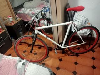 Bicicleta urbana blanca con ruedas rojas