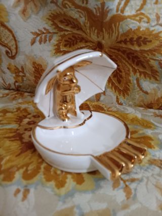 Cinzeiro imaculado com figura dourada