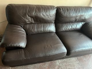 Sofá de piel marrón y patas de madera