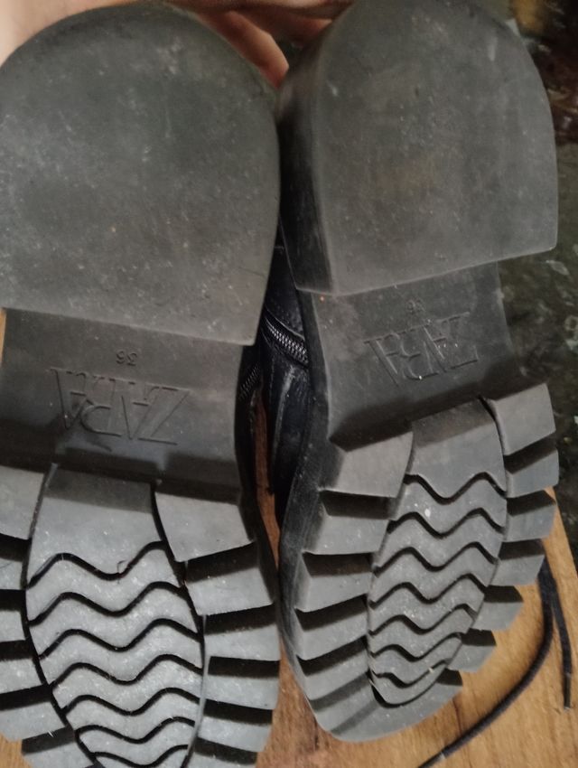 Botas negras con hebilla y cordones.
Son de piel.