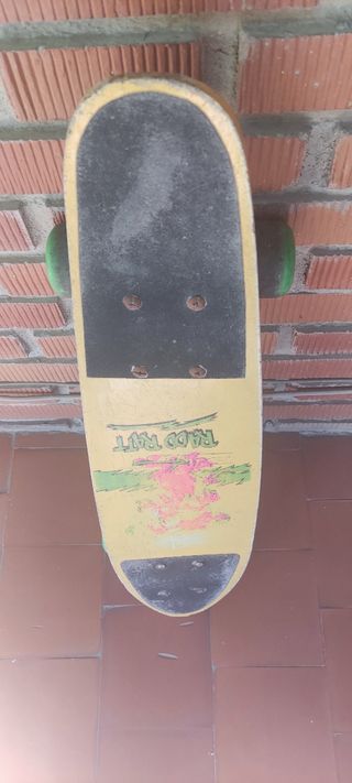 Monopatín amarillo con ruedas verdes