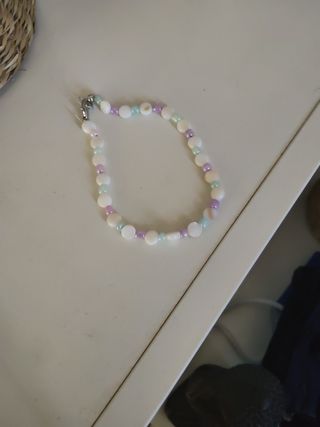 Pulsera artesanal perlas moradas y blancas.