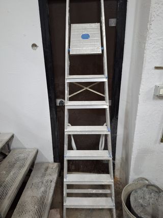 Carretilla, herramientas y escalera