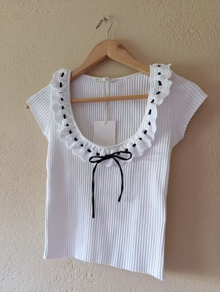 Blusa blanca con volantes y lazada