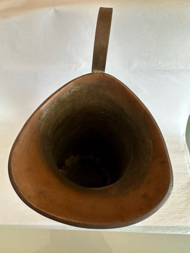 Jarra de metal con diseño azteca