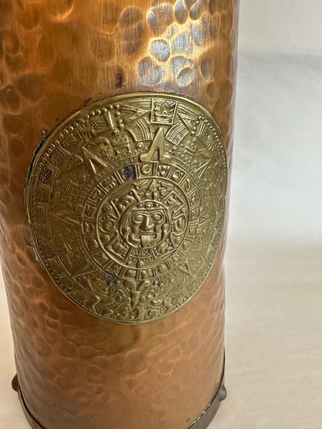 Jarra de metal con diseño azteca