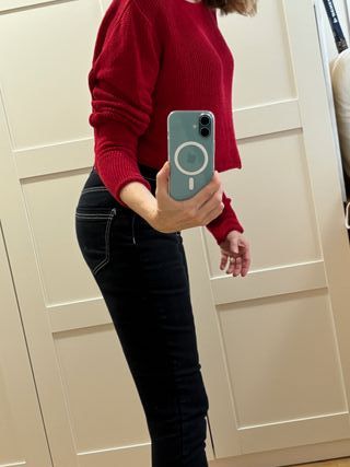 Pantalón vaquero negro y suéter rojo