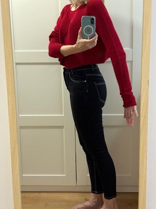 Pantalón vaquero negro y suéter rojo