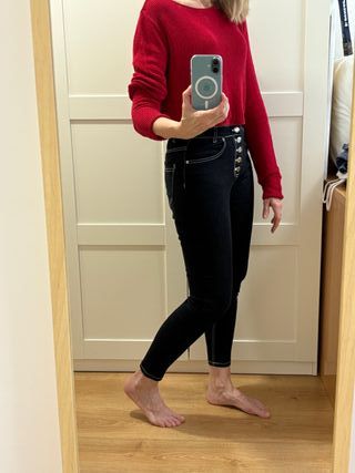 Pantalón vaquero negro y suéter rojo