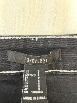 Pantalón vaquero negro y suéter rojo