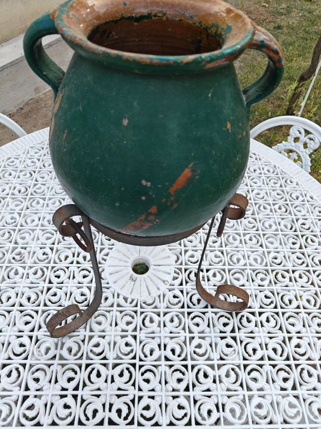 Orza de barro antigua con macetero de hierro