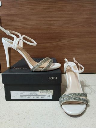 Zapatos de tacón blancos con pedrería plateada.