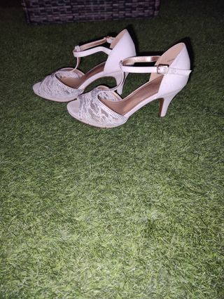 Zapatos de novia blancos de encaje y brillantes.