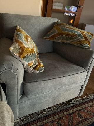 Sillón de tela gris sin cojines.