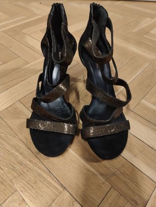 Zapatos de tacón negros y dorados muy estables.