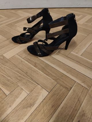 Zapatos de tacón negros y dorados muy estables.