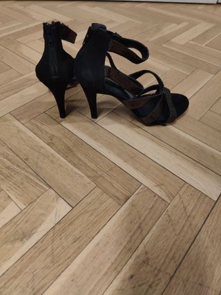 Zapatos de tacón negros y dorados muy estables.