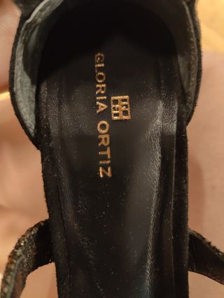 Zapatos de tacón negros y dorados muy estables.