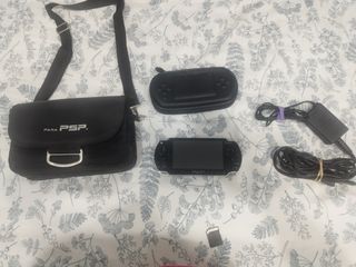 PSP Sony Negra con funda y bolsa de transporte.