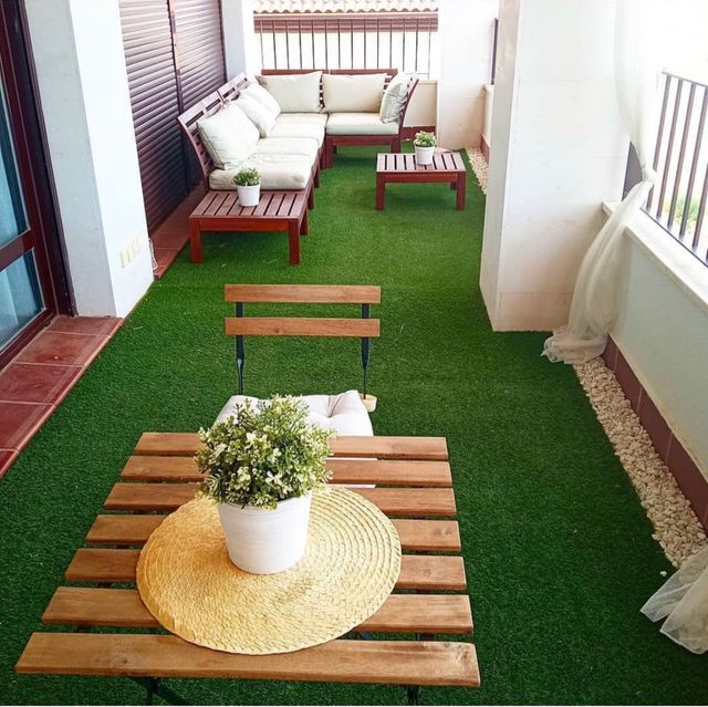 Sofás de exterior de madera con cojines y 2 mesas.