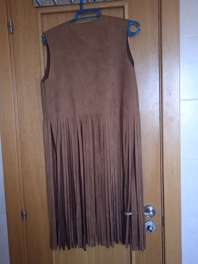 Chaleco con flecos y detalles dorados.