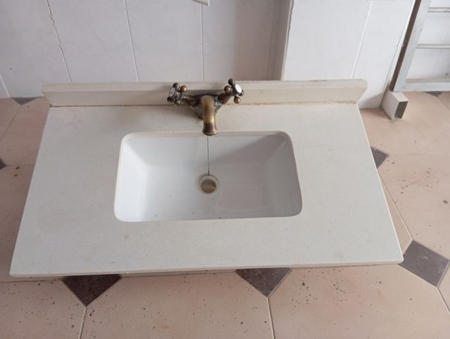 Encimera de piedra con lavabo y grifo .
