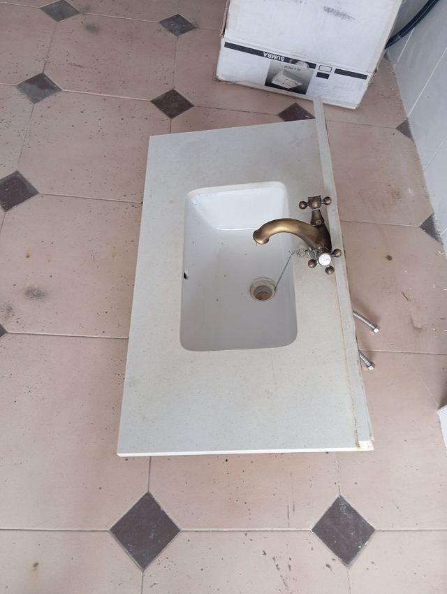 Encimera de piedra con lavabo y grifo .