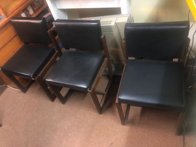Sillas de comedor negras de cuero.