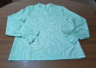 Blusa verde claro estampada de manga larga.