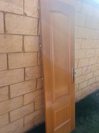 Puerta de madera con manilla dorada
