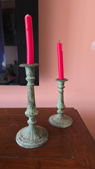 Candelabros de metal verde con velas rojas
