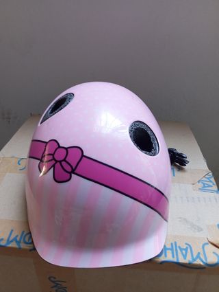 Casco infantil rosa con diseño de lazo