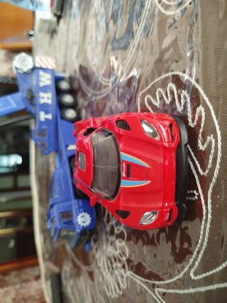 Coche de juguete rojo y grúa azul