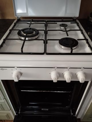 Cocina a gas blanca 3 fuegos y horno con rejilla.