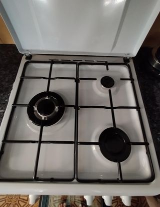 Cocina a gas blanca 3 fuegos y horno con rejilla.
