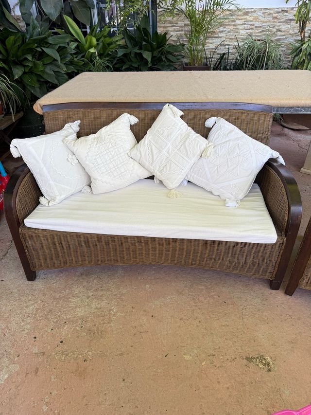 Sofá y sillón de ratán marrón con cojines blancos