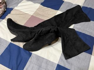 Botas altas negras por encima de la rodilla