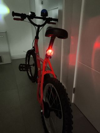 Bicicleta 16" roja.  Ruedines, luces y sirena.