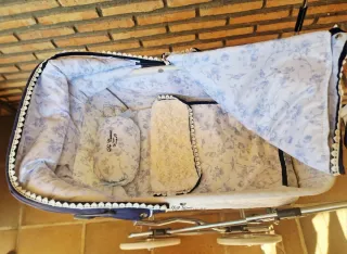 Cochecito de bebé Reborn azul y blanco.